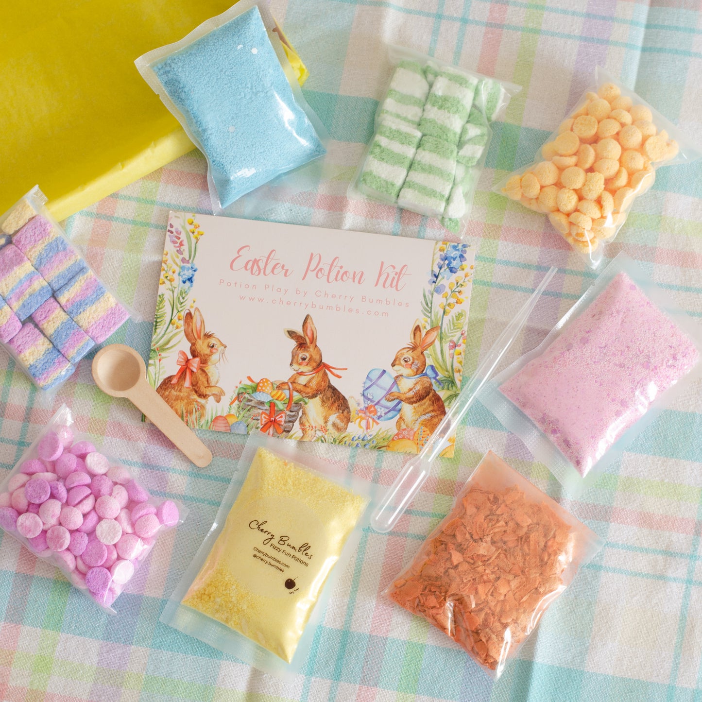 Easter potion kit with colorful packets and a recipe card on a checkered tablecloth.